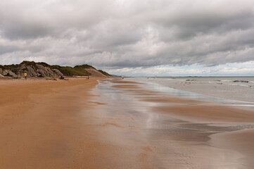 A beach with a cloudy sky in the background