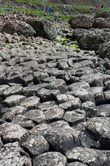 A rocky area with a lot of rocks and a few people walking around