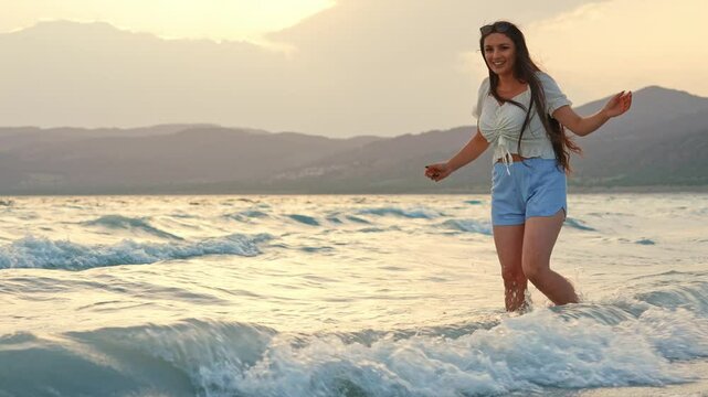 Woman Playing in Sea Waves at Sunset, Coastal Scene