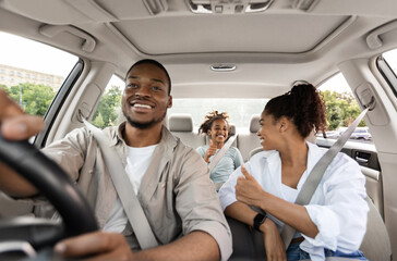 New Car. Happy Black Family Of Three Driving Own Car Gesturing Thumbs Up Approving Vehicle Sitting...