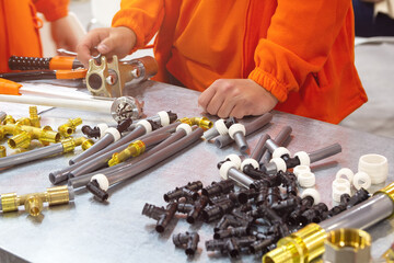 Master demonstrates components for installation of cross-linked polyethylene water pipes