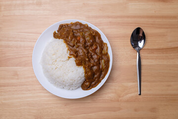 top view of homemade Japanese curry rice with beef carrot beans and onion in white dish on wood table