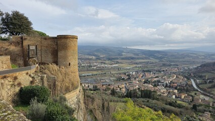 Fototapeta premium View of the Albornoz Fortress in Orvieto, Italy, perched on a cliff with a panoramic backdrop of the modern town and Umbrian valley below.