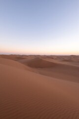 Fototapeta premium An aerial view of a sandy desert landscape at sunset.