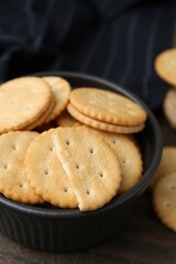 Tasty salty crackers on wooden table, closeup