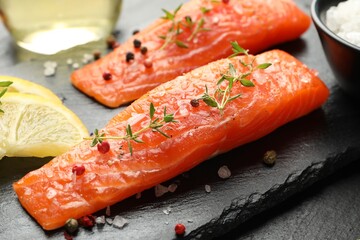 Seafood. Pieces of salmon fillet, spices and lemon on table, closeup