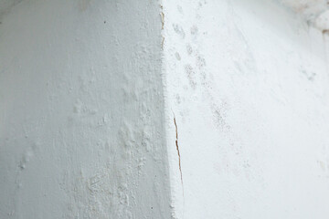 Cracked and moldy white wall corner
