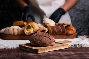 Chocolate concha bread on a rustic wooden table.