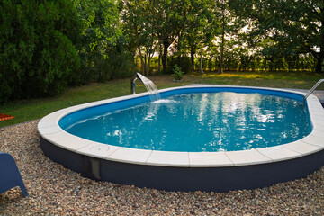Empty clean outdoors swimming pool in the garden, no people 