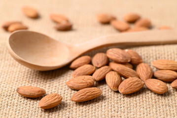 Raw almond nut seed with wooden spoon, Food ingredient