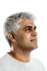 Obraz premium Pure white solid background. An expressive and modern man in a studio setting. Trendy men's wavy fringe haircut - midlife indian man with short hair. Visual idea of style for aging men.