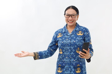 Beautiful woman in Indonesian civil servant uniform holding cell phone while presenting sideways