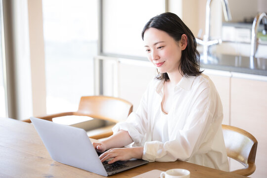 パソコンを見ながら考える女性　ECサイトでの買い物などのイメージ