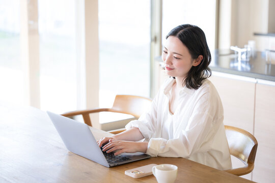 パソコンを見ながら考える女性　ECサイトでの買い物などのイメージ