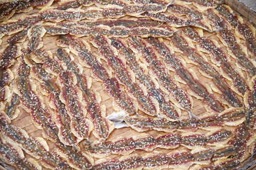 Dried sweet  yellow stripe scad fish with sesame seeds on brown bamboo tray background