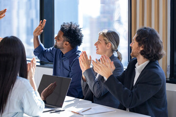 Team of happy diversity business people agreement on deal over new strategic strategy project on investment real estate with recognition and applause from other colleague for partnership