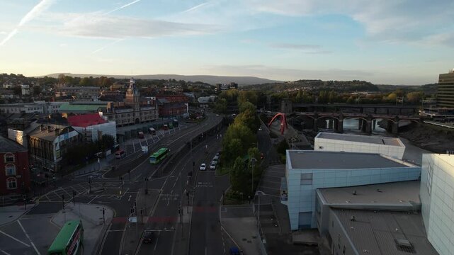 Traffic in city at dusk. Forwards fly above street around Market square bus terminal and roundabout. Newport, Wales, UK