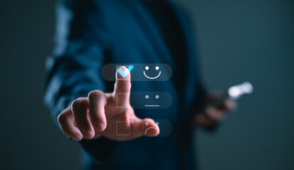 Customer satisfaction and digital feedback concept. Businessman selecting happy face icon on virtual screen for rating service experience using futuristic interface.