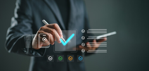 Quality control and task management concept. Businessman using stylus to mark completed checklist on virtual interface for monitoring process accuracy and workflow efficiency.