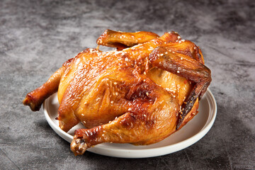 A whole delicious roasted chicken on table.