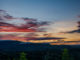 Fototapeta premium Scenic view dramatic beautiful sunset sky. Natural Sunset Sunrise on meadow silhouette shadow dark land. Vibrant dramatic sky on sunset, dawn, sunrise in Countryside. Landscape Colorful Sky At Sunset