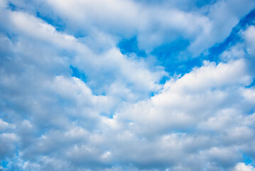 Fototapeta premium Blue sky fluffy white clouds on summer season bright clear skyline with beautiful cloudscape. Panorama blue sky clouds pattern on daylight with copy space. Cumulus cloudscape air climate sunny day