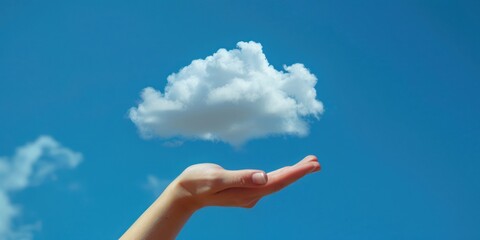 A hand holding a small, fluffy white cloud against a clear blue sky.