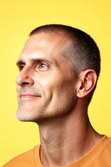 Fototapeta premium Conceptual art graphic of style for aging men. Yellow solid background. A warm and friendly man radiating happiness. Modish men's buzz cut haircut - midlife white man with red hair.