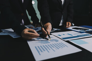 Teamwork with business people analysis cost graph on desk at meeting room. double exposure...