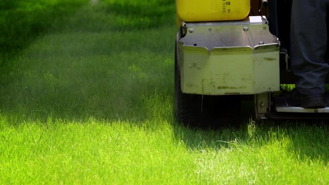 Professional grass spraying with a large lawn mower, landscaping service