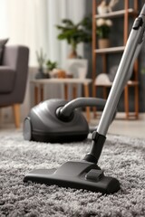 Vacuum cleaner on gray carpet in living room close up shot of vacuum head and soft area rug indoor home setting
