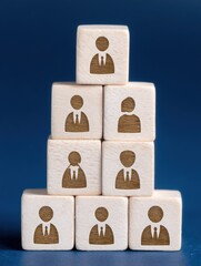 Pyramid of wooden blocks showing business hierarchy and organizational structure on blue background concept of leadership