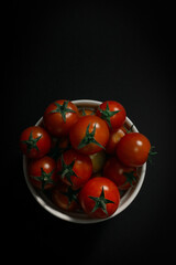 Top View of Cherry Tomatoes in White Bowl on Black Background – Minimalist Culinary Flat Lay
