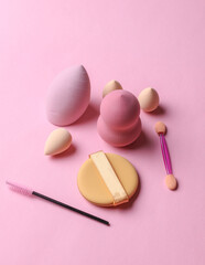 Set of cosmetic sponges blenders for makeup and accessories on pink background