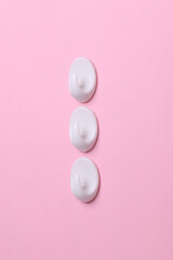 White plastic hanger hooks on pink background