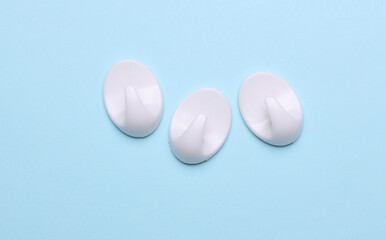 White plastic hanger hooks on blue background