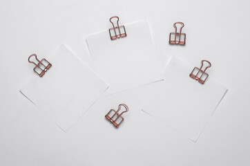 Memo white square sheets of paper with binder clips on white background