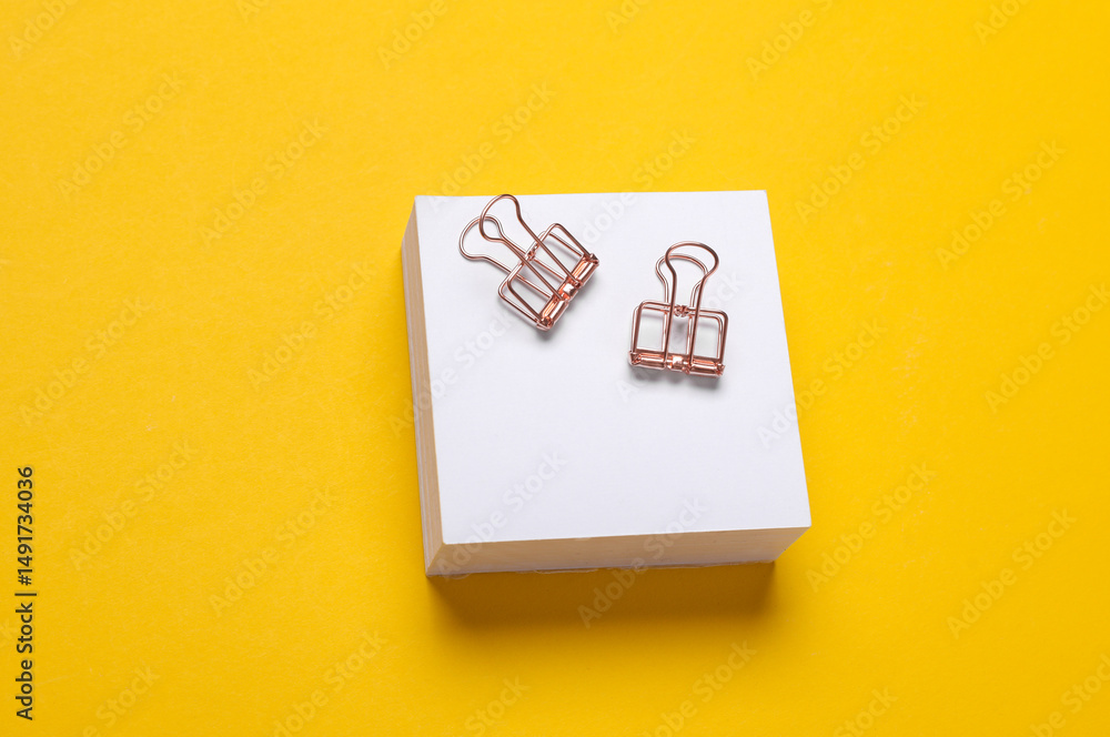 Poster stack of white memo papers with binders on yellow background