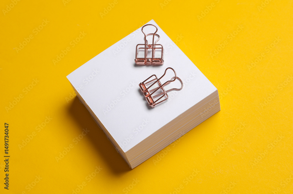 Poster stack of white memo papers with binders on yellow background