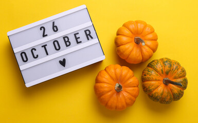26 october letterboard text on LED Lightbox with pumpkins, yellow background. Seasonal calendar....