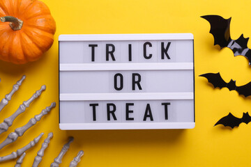 Lightbox with text TRICK OR TREAT and holiday decor. Halloween celebration. Flat lay