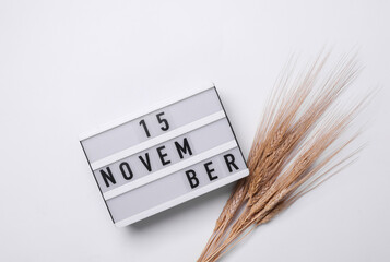15 november letterboard text on Lightbox with dry wheat, white background. Seasonal calendar. Flat...