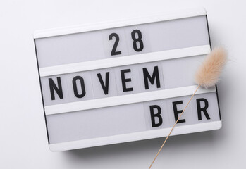 28 november letterboard text on Lightbox with dry lagurus flower, white background. Seasonal...