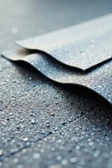Close-up view of dark gray material with water droplets, showcasing texture and water resistance