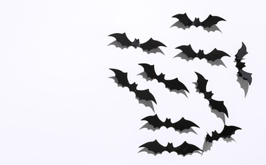 Halloween decoration concept. Black paper bats flying on white background. Top view