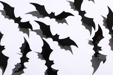 Halloween decoration concept. Black paper bats flying on white background. Top view