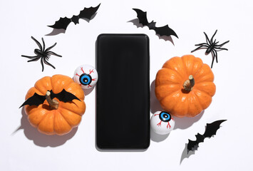 Smartphone with Halloween decor on white background