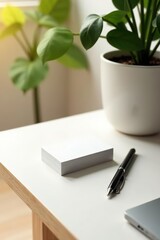 A stack of blank cards rests on a minimalist desk beside a pen and a potted plant, ready for your message.