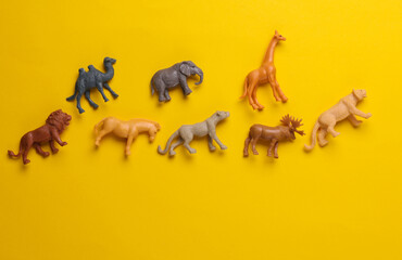 Toy zoo, set of wild animals on yellow background. Top view