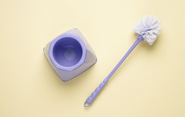 Toilet brush on yellow pastel background. Top view